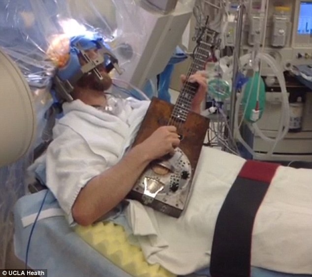 مريض يلعب على الغيتار اثناء خضوعه لجراحة في الدماغ
